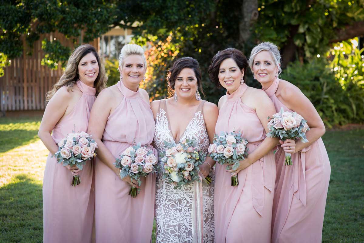 Bride and bridesmaids with pink dresses and pink and white flowers